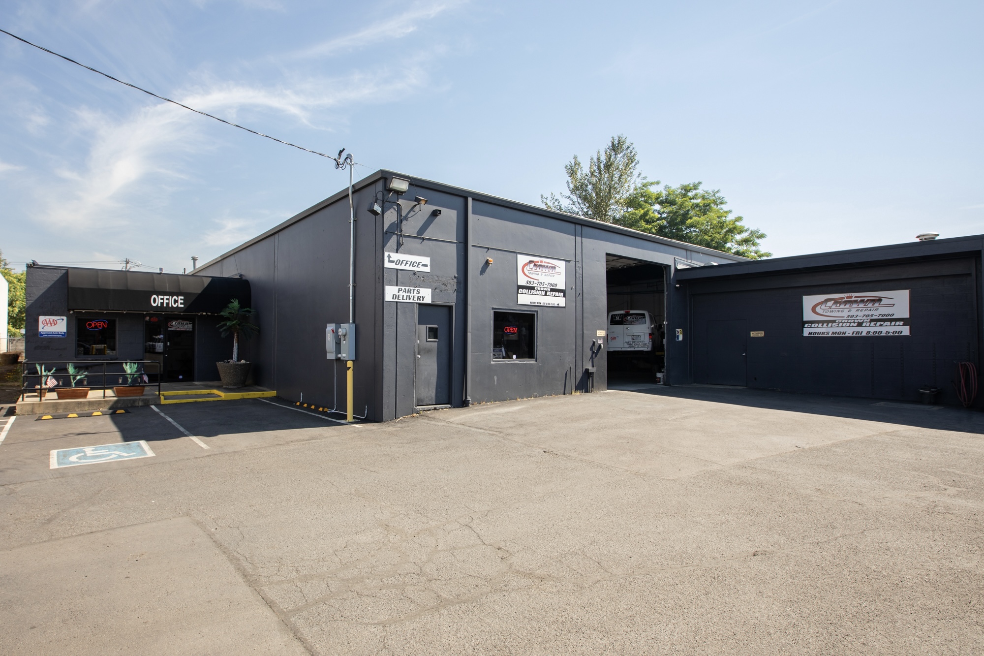 Exterior view of the Crown Towing & Collision Repair building and customer parking area in Portland