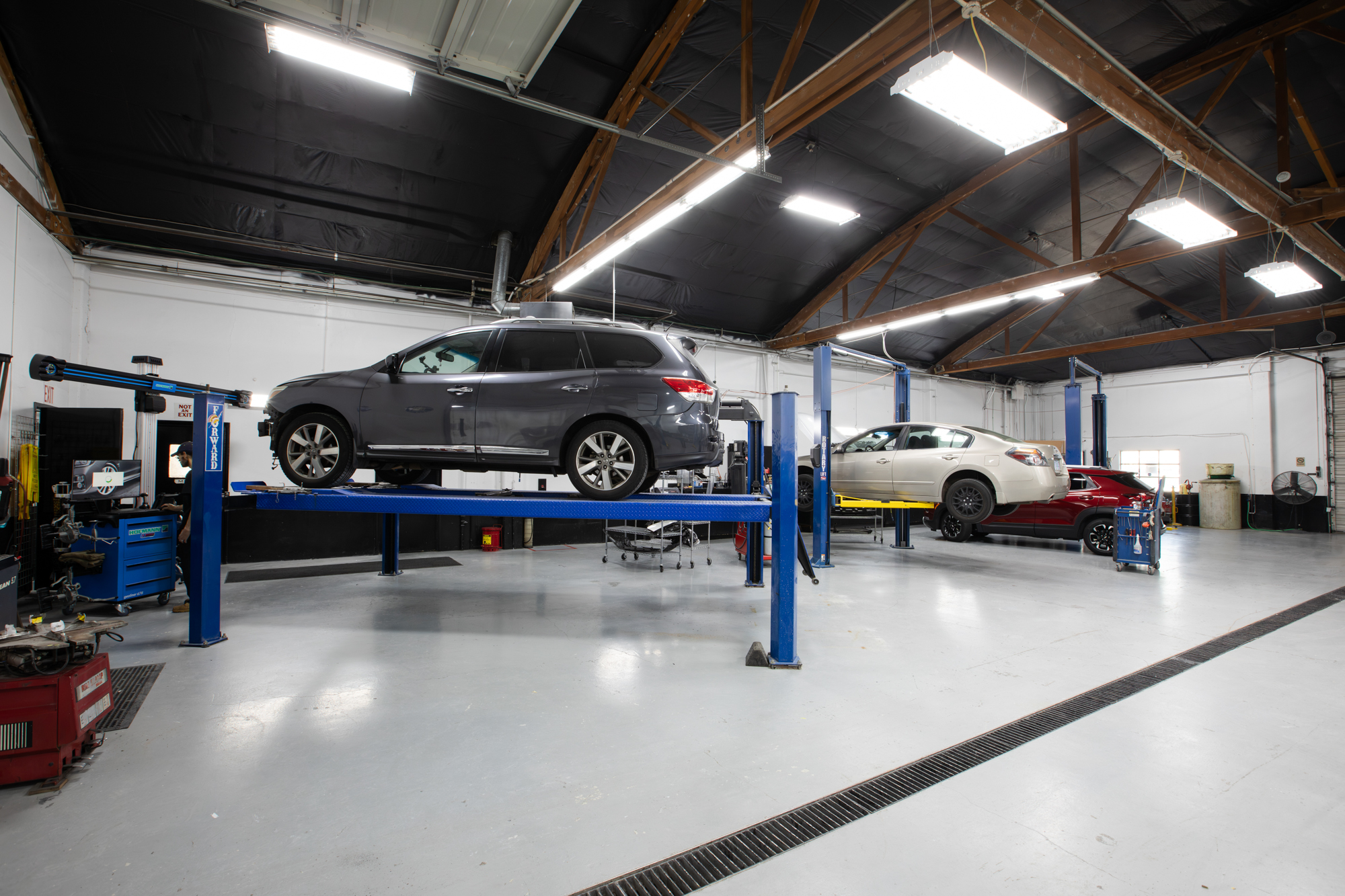 Crown Collision Repair shop floor with vehicles on lifts and alignment rack