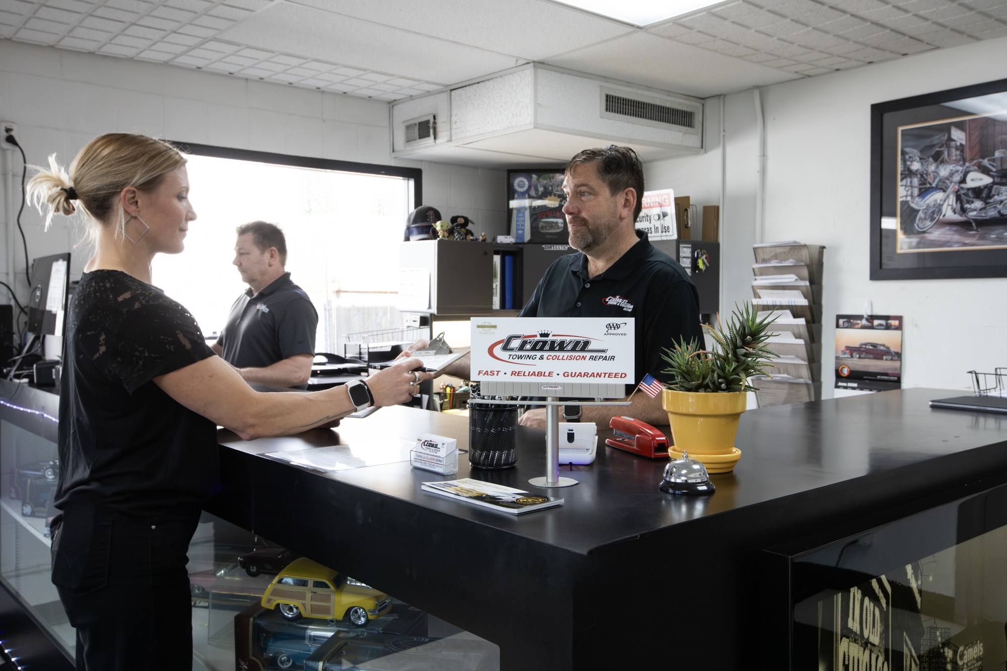 Crown Towing & Collision Repair estimator assisting a customer at the SE Portland front desk