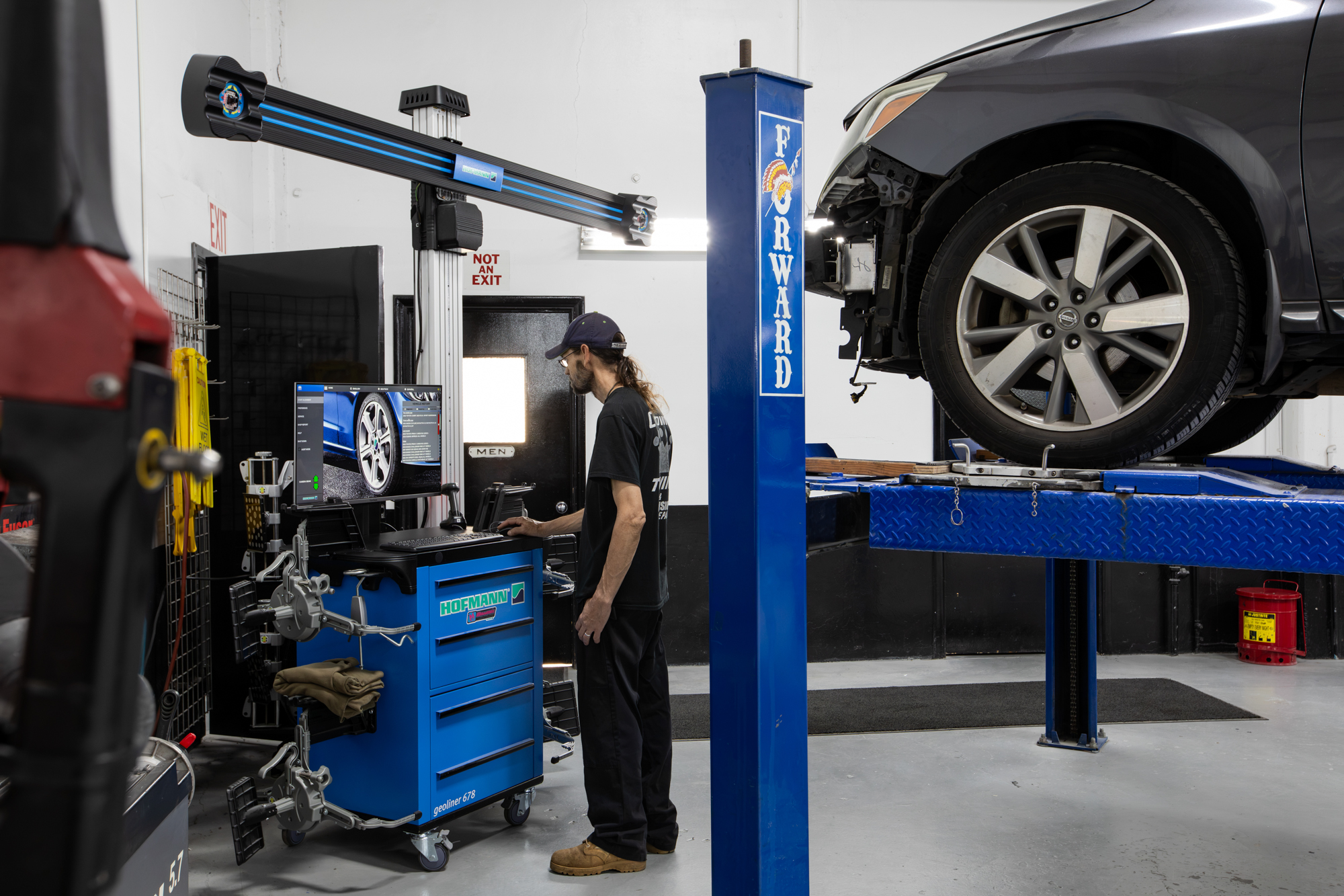 Technician using the wheel alignment station inside Crown's Portland repair shop