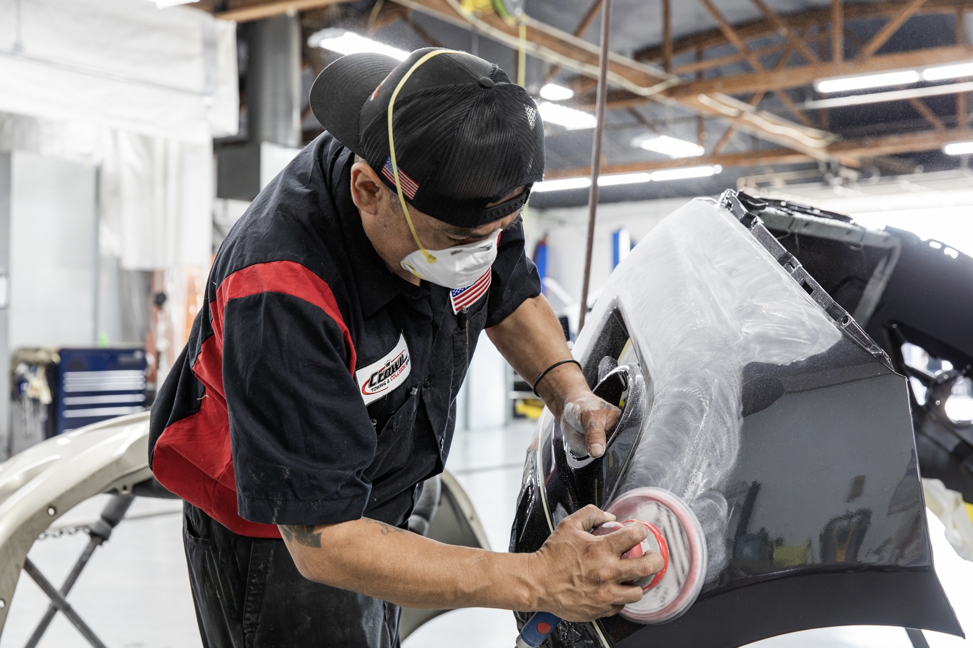 Crown body tech sanding a bumper cover in prep for paint refinishing