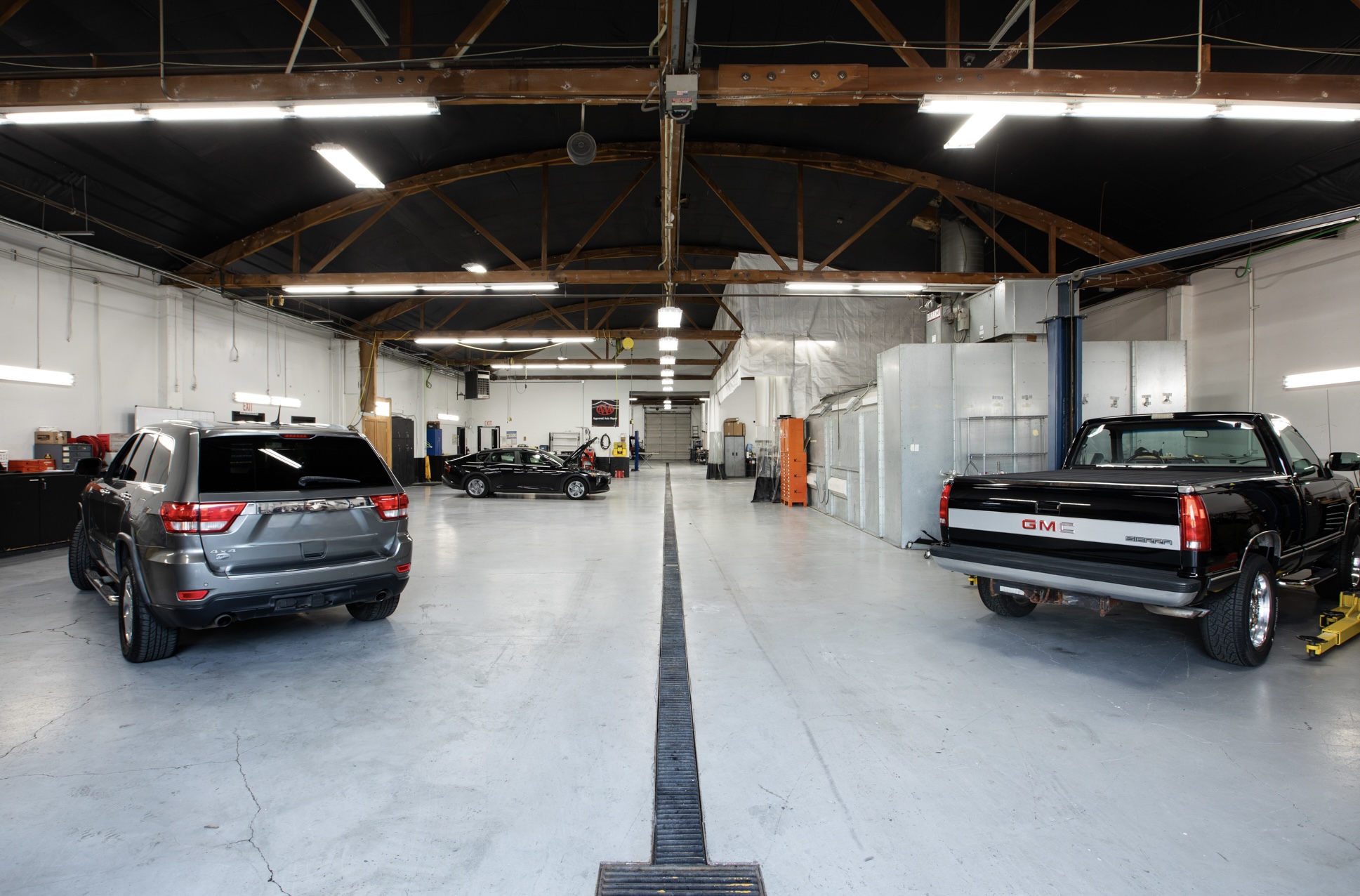Wide interior view of Crown's main shop floor with customer vehicles staged across service bays
