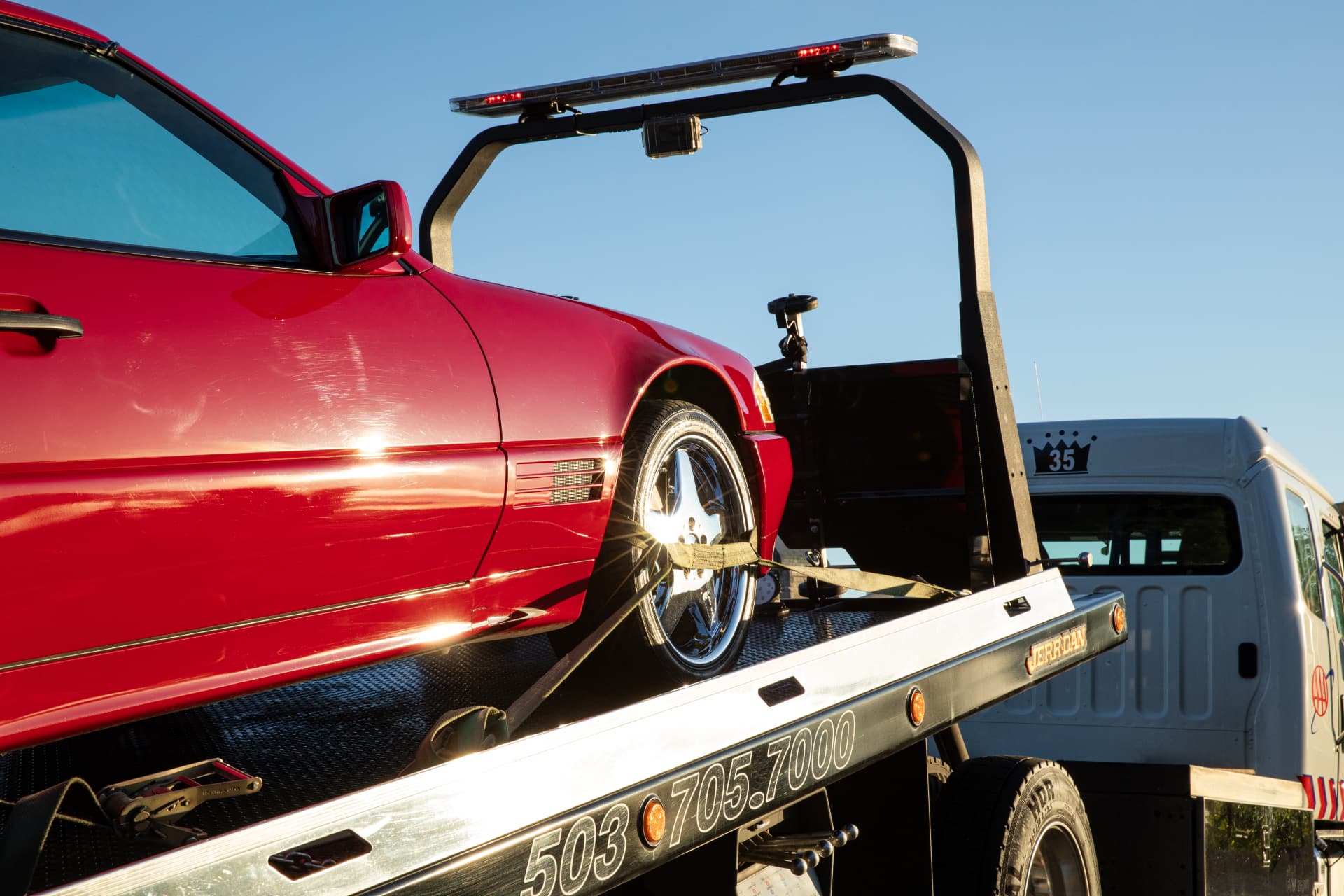 Crown Towing flatbed truck with a red vehicle secured on the deck