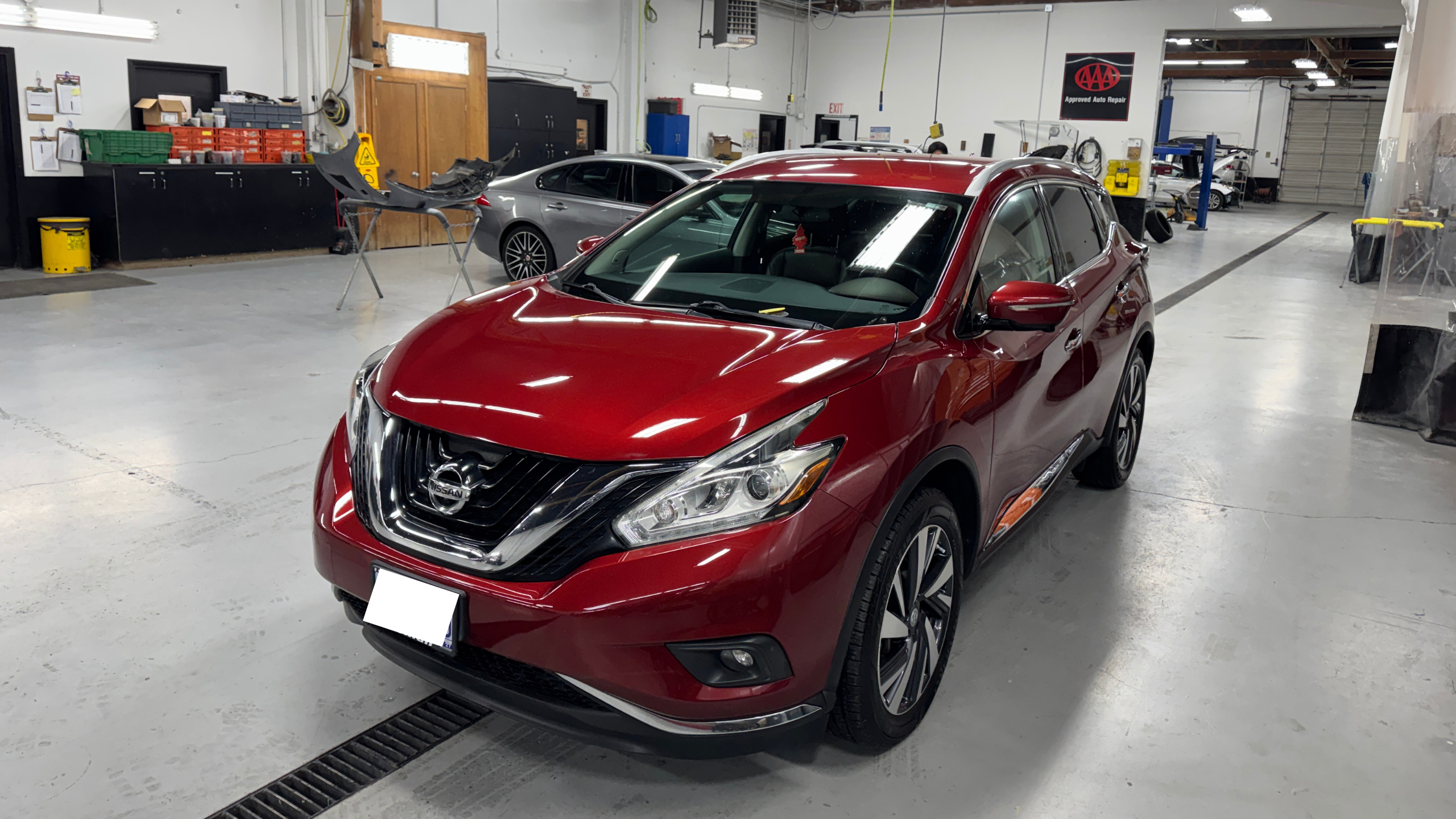 Crown shop technician inspecting a customer vehicle before starting collision repair work
