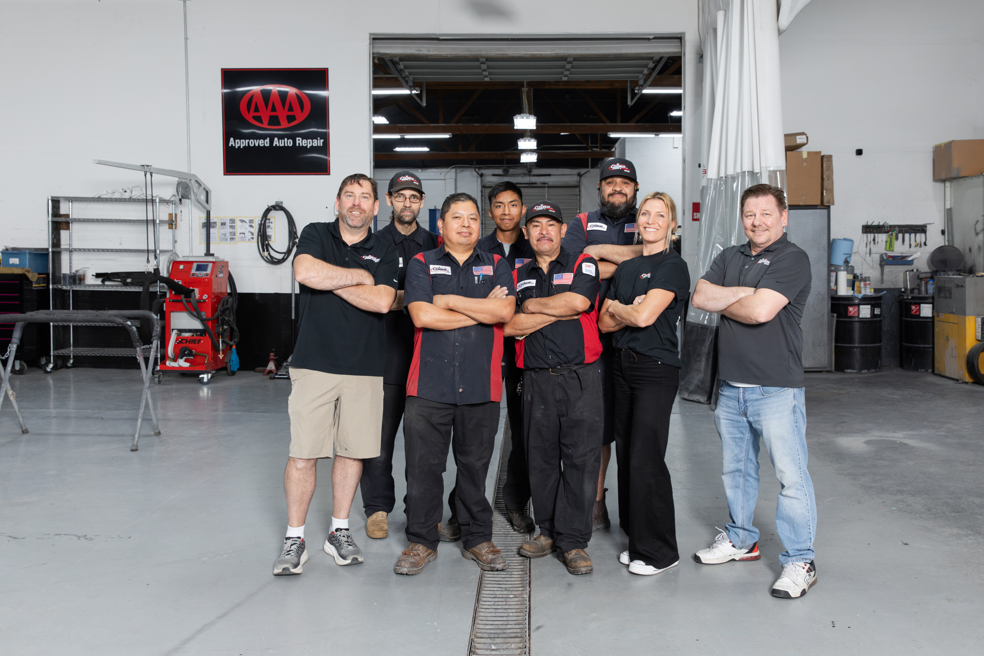 Crown Towing & Collision Repair team members standing together inside the SE Portland shop