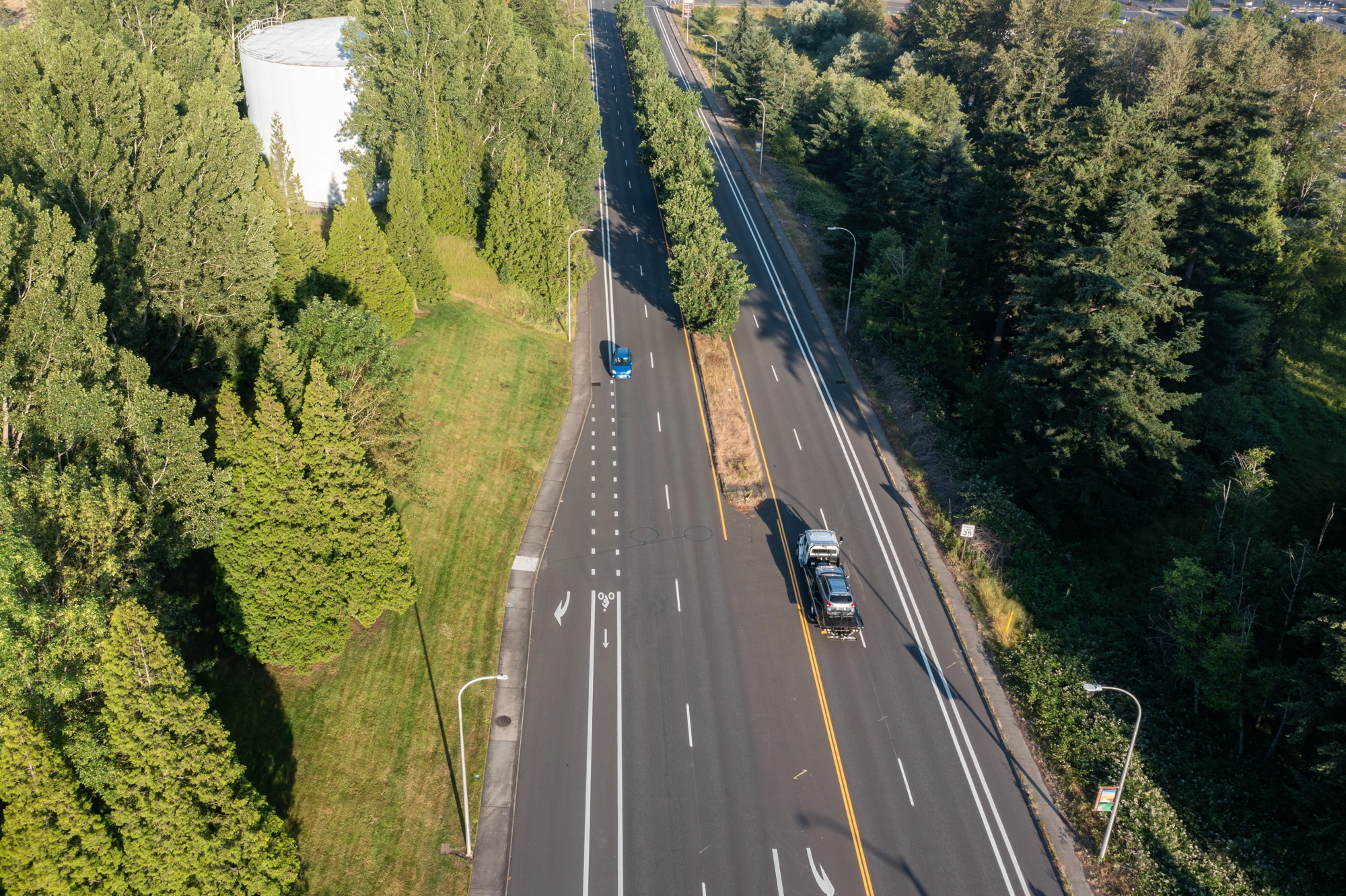 Aerial view of a Crown flatbed tow truck transporting a vehicle on a Portland-area roadway