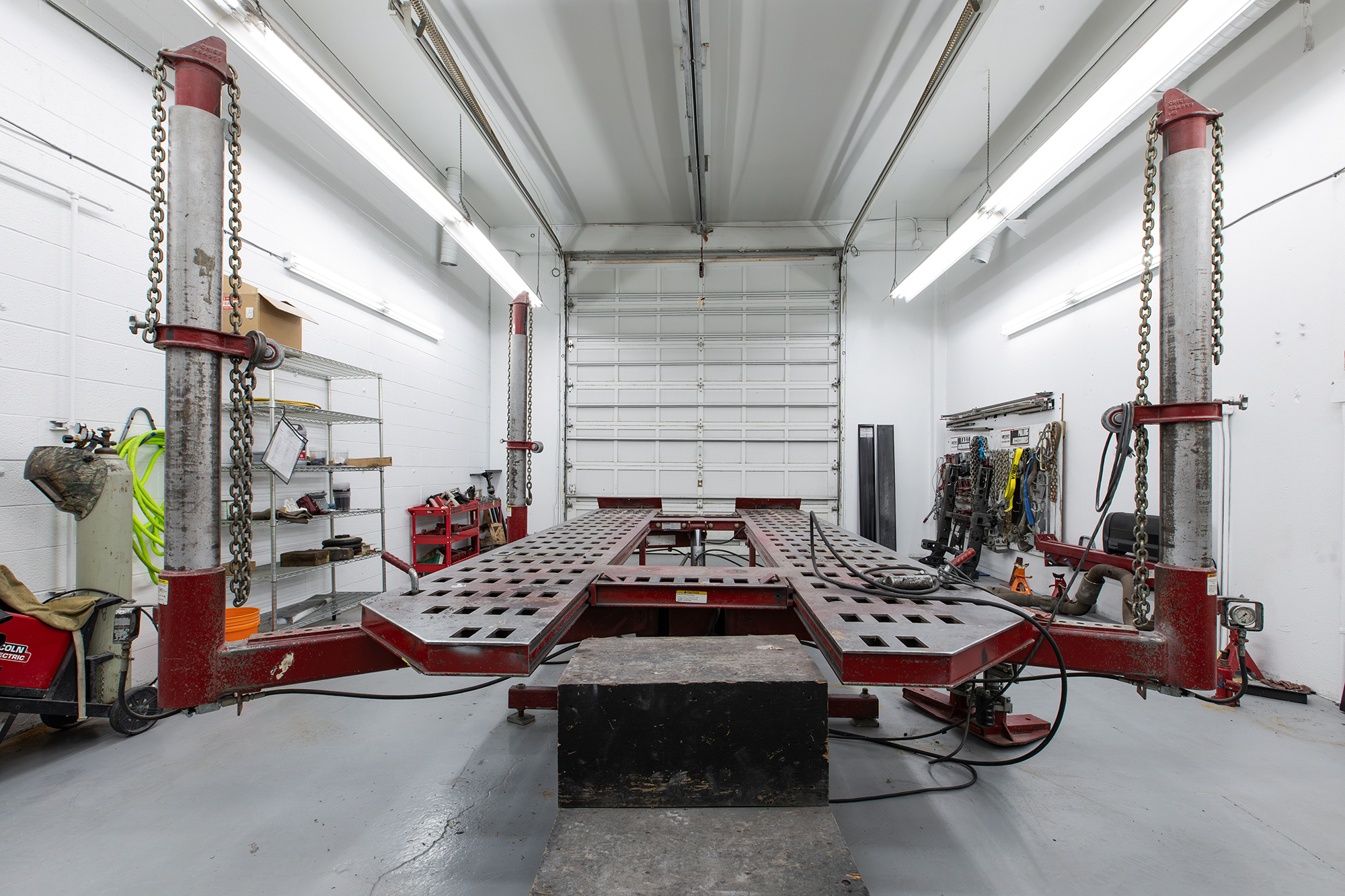 Wide view of Crown's frame straightening rack and adjacent collision repair bay